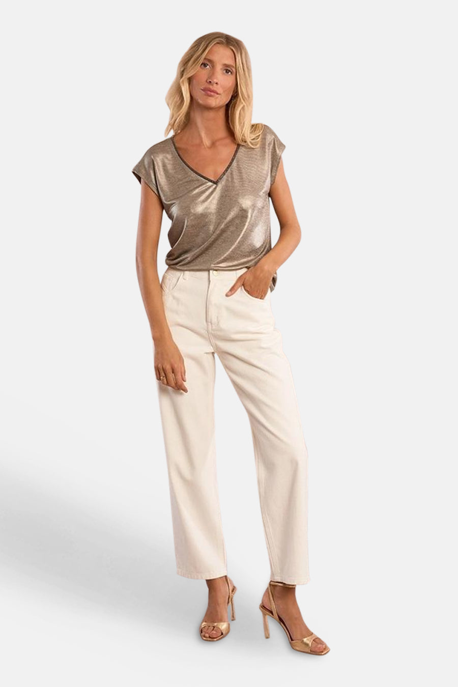 T-shirt doré à manches courtes de Molly Bracken, avec un col en V et porté avec un pantalon blanc.

