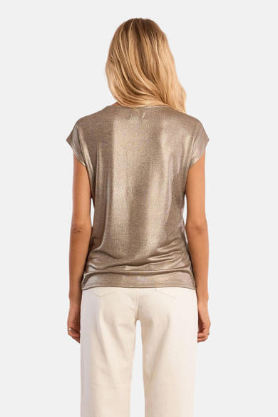 T-shirt doré à manches courtes de Molly Bracken, avec un aspect brillant, porté avec un pantalon écru.