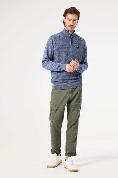 Pull à col roulé bleu de GARCIA, avec fermeture éclair courte, porté avec un pantalon cargo kaki et des baskets blanches.