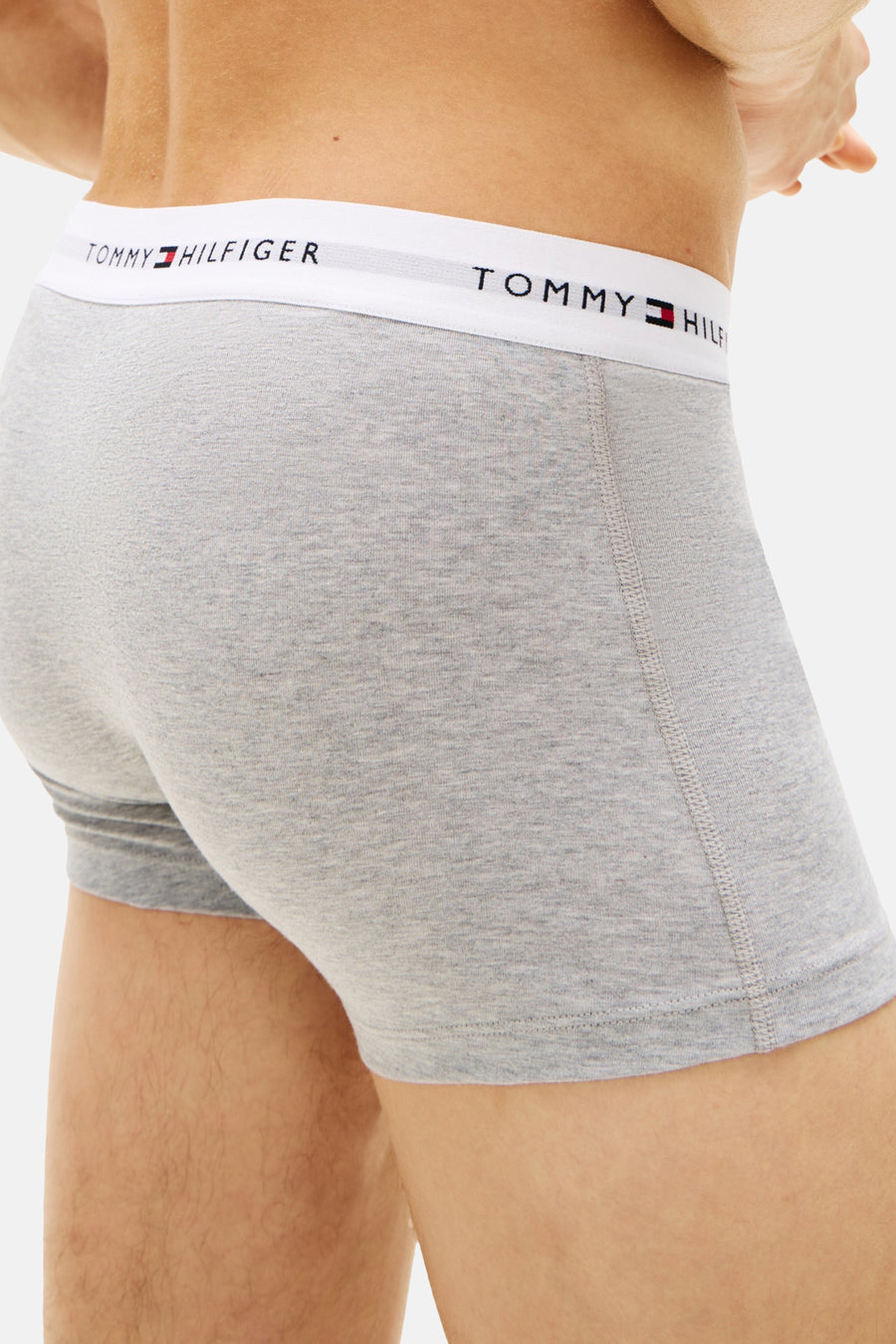 Boxer gris chiné de Tommy Jeans, avec une ceinture blanche logotypée apparente, en vue de côté.
