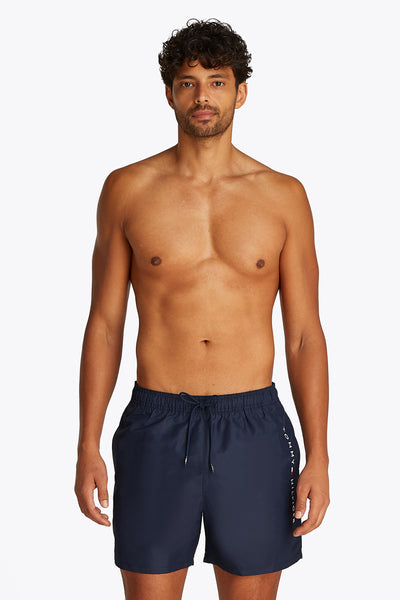 Marineblauwe zwembroek van Tommy Hilfiger, gedragen door een man zonder bovenkleding.