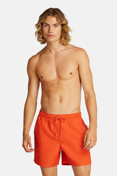 Oranje zwembroek van Tommy Hilfiger, gedragen door een naakt bovenlijf model met blond haar.