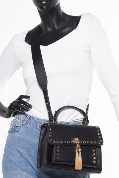 Sac à bandoulière noir Gaudi Jeans avec bandoulière et détails dorés, porté avec un jean clair et un haut blanc.
