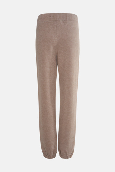 Beige joggingbroek van Guess, met een geribbelde textuur en elastische enkels, op een effen achtergrond.