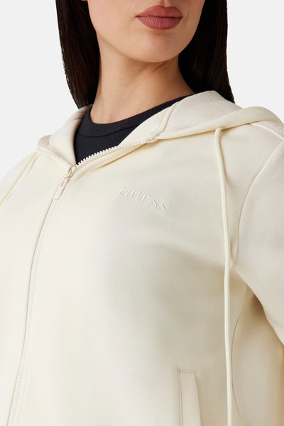Gilet écru de Guess, avec fermeture éclair et capuche à cordon, porté sur un t-shirt noir.