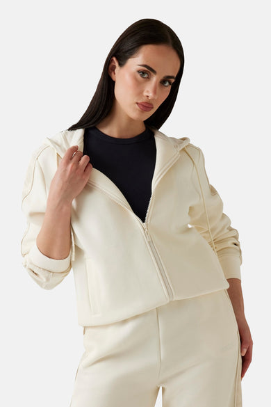 Ecru gilet van Guess, met een ritssluiting en gedragen over een zwart T-shirt.