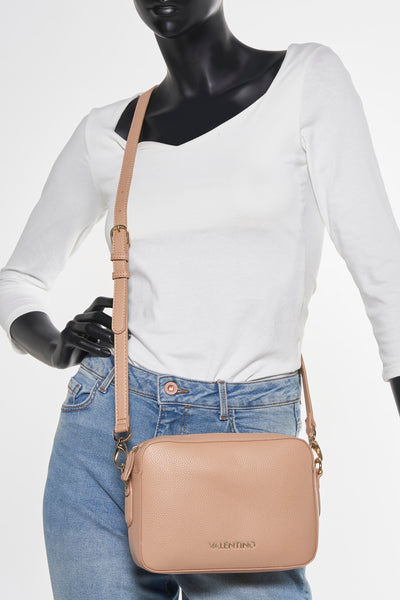 Sac à bandoulière beige de VALENTINO BAGS, porté sur un mannequin avec un t-shirt blanc et un jean bleu.
