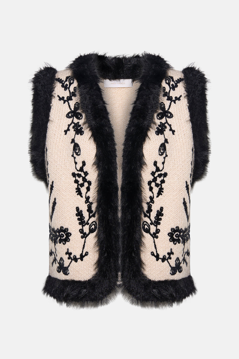 Gilet en tricot multicolore d'AMELIE ET AMELIE, avec bordure en fausse fourrure noire et broderies florales noires.
