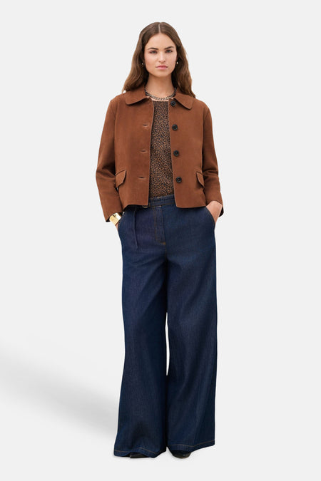 Veste courte marron de CAROLL à col et poches, portée sur un haut léopard et un jean large.