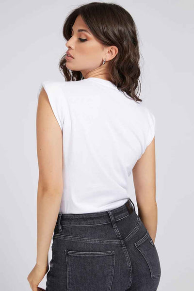T-shirt blanc de Guess, porté avec un jean taille haute anthracite.