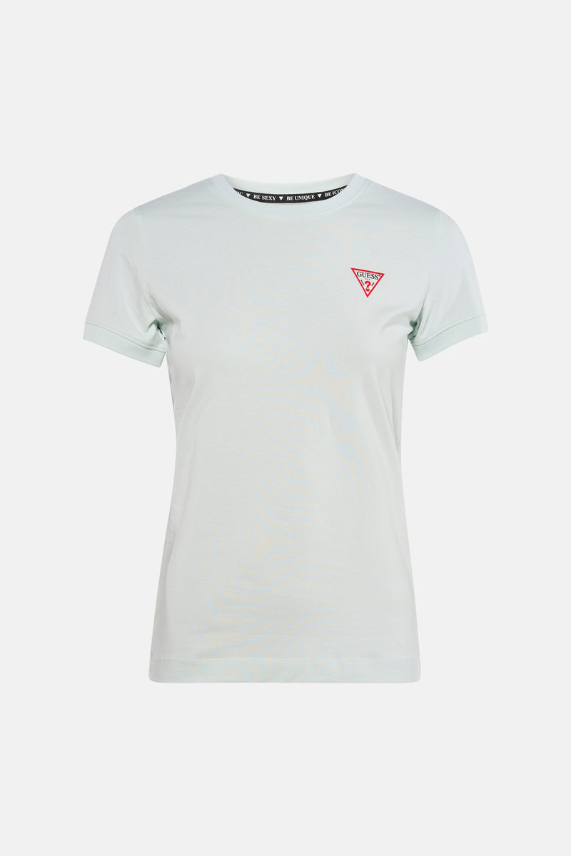 Mintgroen T-shirt met korte mouwen van Guess, met rood logo, gedragen met een wijde blauwe spijkerbroek.