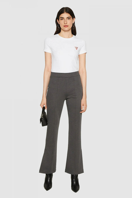 Witte, enkelshose T-shirt van Guess, gedragen met een uitgestrekte grijs broek en zwarte puntbroekens.