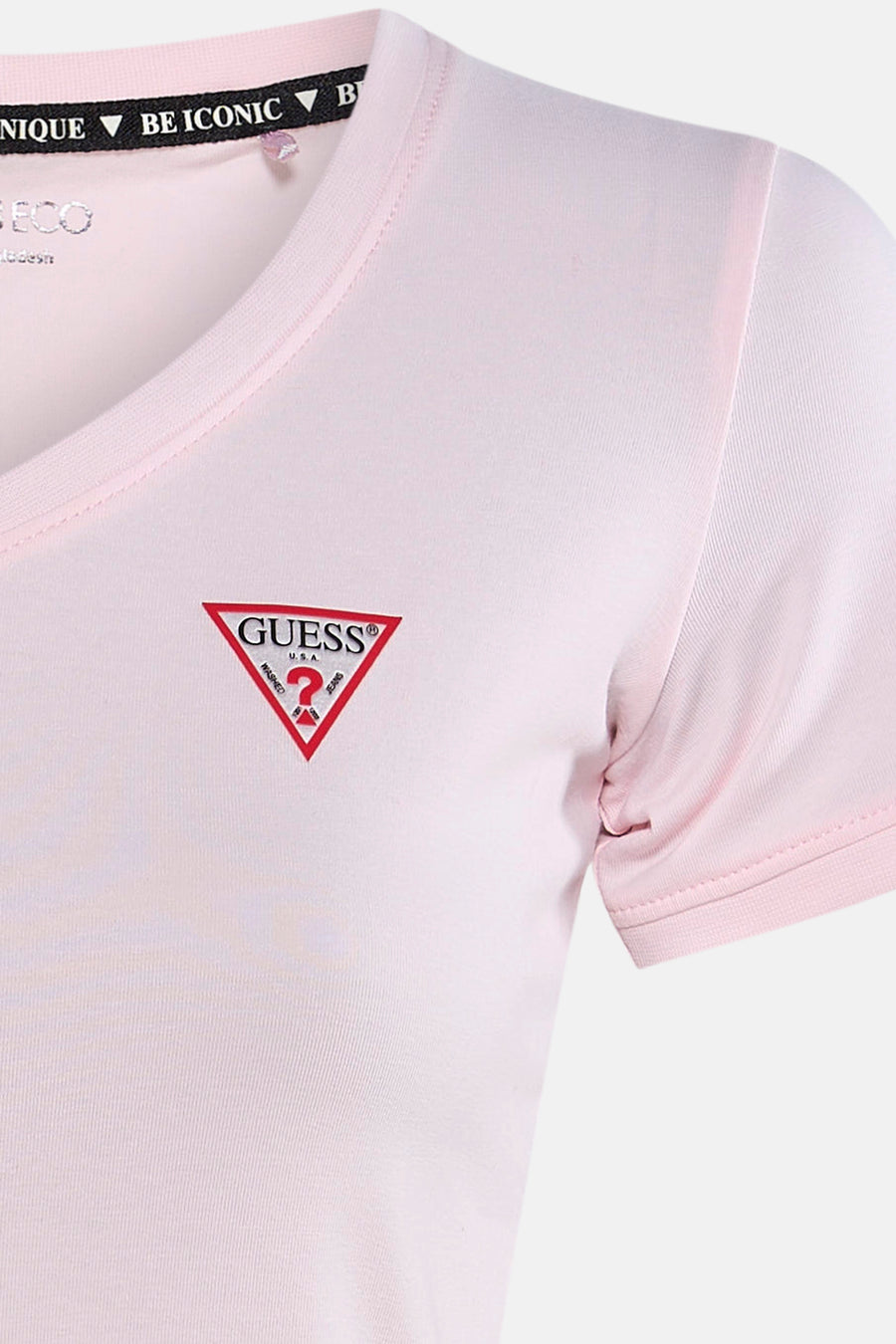 Top uni manches courtes rose de Guess®, avec logo rouge distinctif sur le devant.
