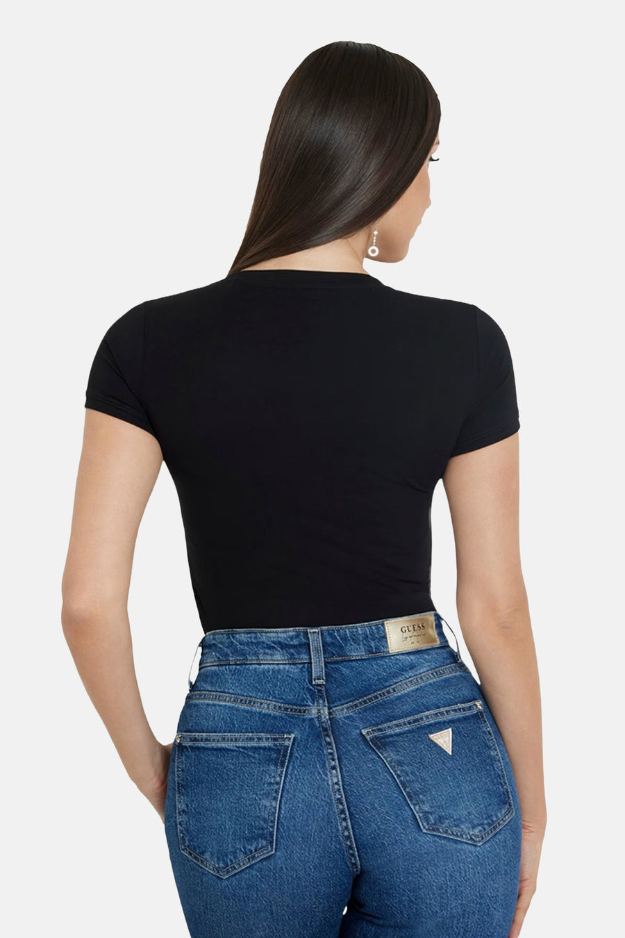 Zwart T-shirt met korte mouwen van Guess, gedragen met een blauwe jeans met hoge taille.