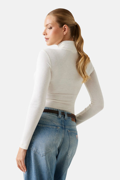 Ecru T-shirt met lange mouwen van Guess, gedragen met een blauwe jeans met hoge taille en een bruine riem.