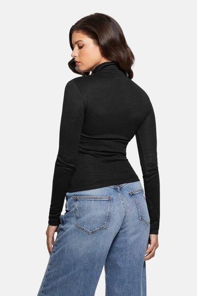 T-shirt à manches longues noir de Guess, porté avec un jean bleu taille haute.