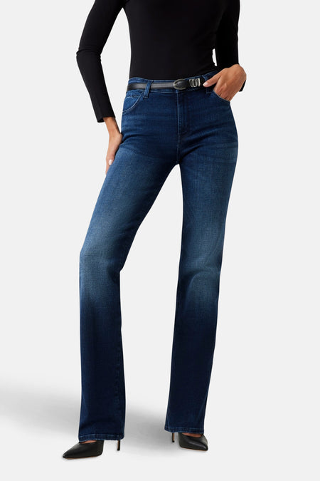 Rechte donkerblauwe spijkerbroek van Guess, gedragen met een zwarte top en een dunne zwarte riem.