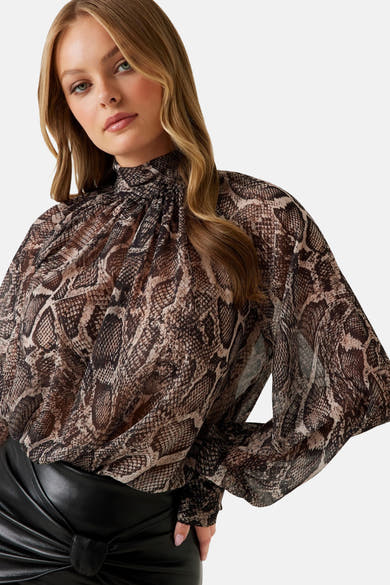 Bruine met lange mouwen van Guess in bruin, met slangenprint en gedrapeerde opstaande kraag, gedragen met een zwarte rok.