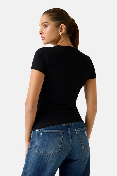 Zwart T-shirt met korte mouwen van Guess, gedragen met een high-waisted, licht verbleekte jeans.
