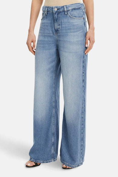 Wijde spijkerbroek in middieblauw denim van Guess, met logopatch op het achterzakje en label in de taille.