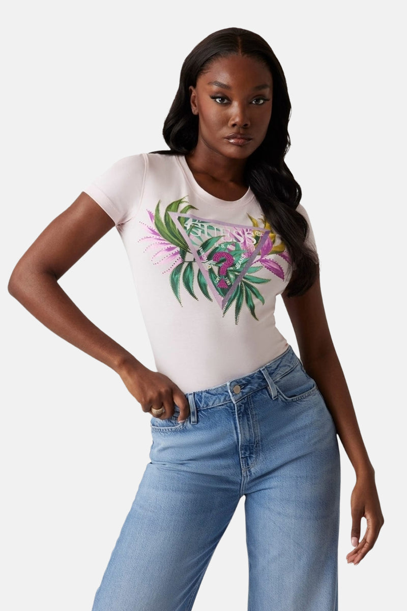 T-shirt rose à manches courtes de Guess, orné d'un imprimé floral dans un motif triangulaire, porté avec un jean bleu.
