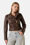 Veste en simili cuir brun de Guess, avec fermeture éclair dorée et détails côtelés aux épaules, portée avec un jean clair.
