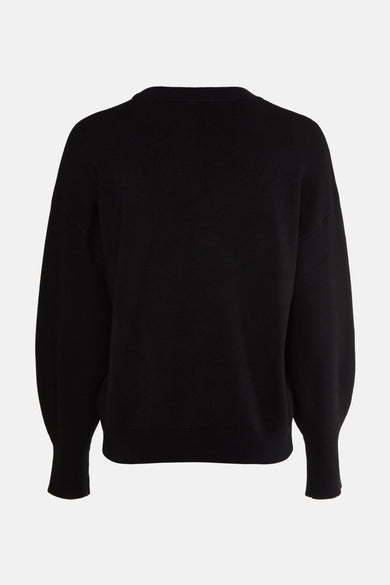 Pull noir à col rond de Guess, avec manches bouffantes et texture tricotée.