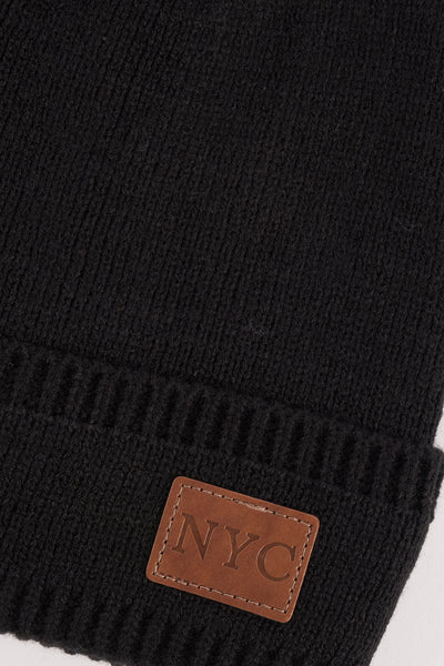 Bonnet noir en tricot d'Access, avec un écusson en cuir portant l'inscription "NYC".
