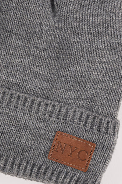 Grijze gebreide muts van Access® met een bruin leren patch met de inscriptie "NYC".