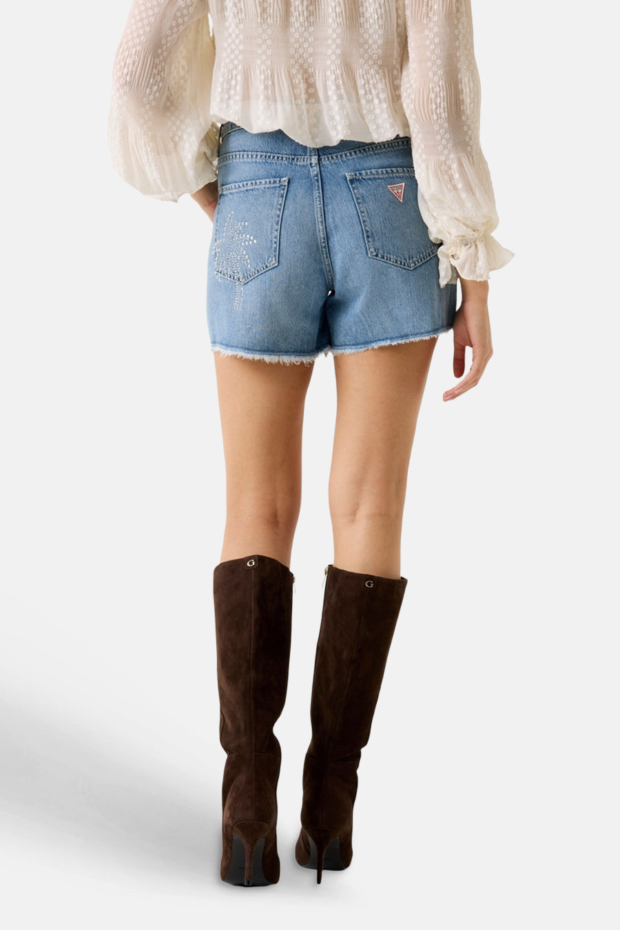 Lichtblauwe spijkerbroekshorts van Guess, versierd met een glinsterend palmboommotief op het linker achterzakje en een rood driehoekig logo. Gerafelde zoom.