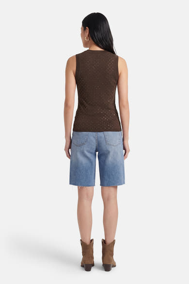 Top sans manches brun de Guess, orné de détails scintillants, porté avec un short en jean et des bottes en daim.