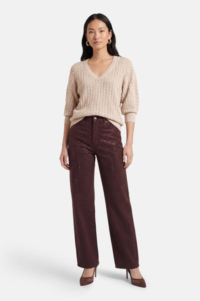 Pull à col en V doré de Guess®, avec une texture tricotée et des manches bouffantes.