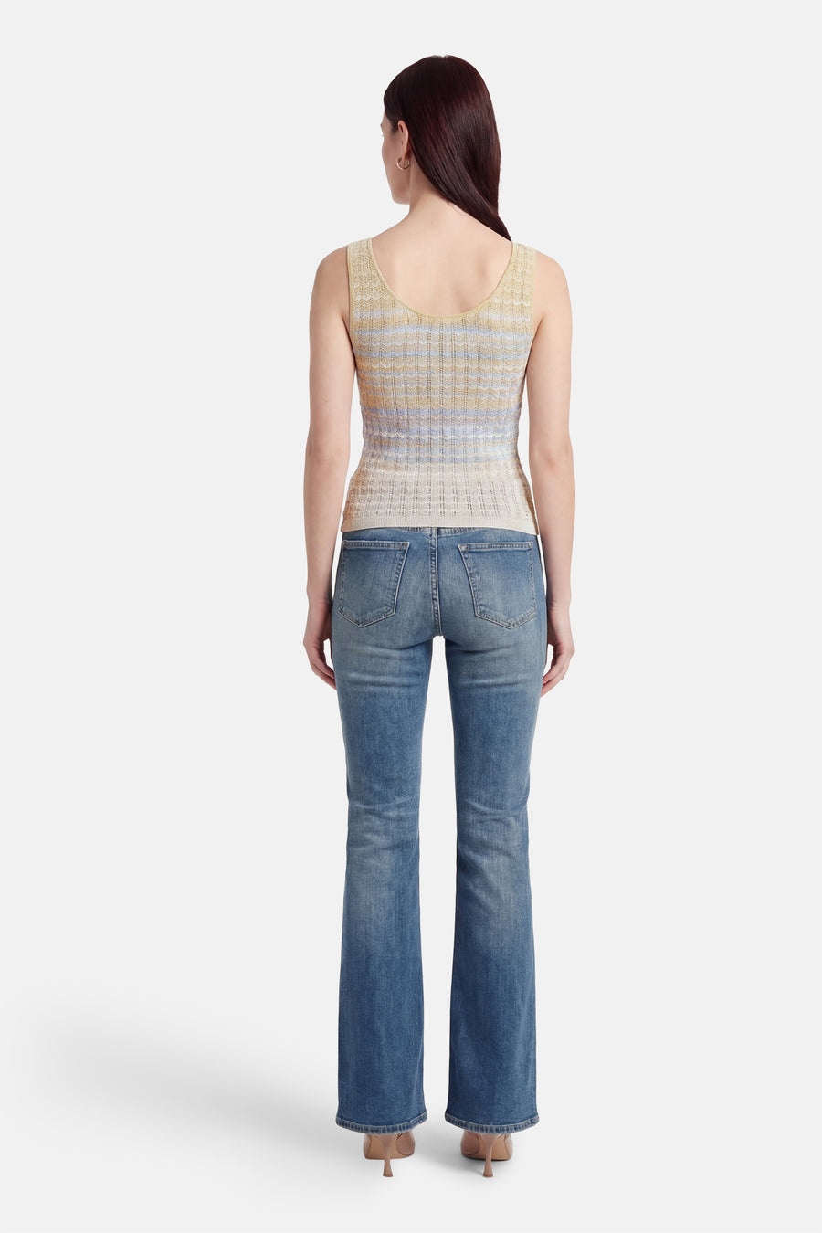 Top sans manches multicolore de Guess®, avec un motif à rayures horizontales et porté avec un jean évasé et des talons hauts.
