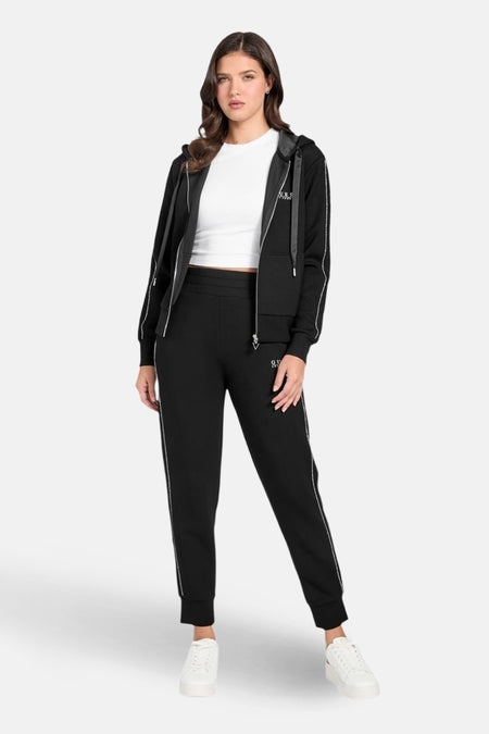 Zwart trainingspak van Guess, bestaande uit een hoodie met rits en een joggingbroek, met witte streepdetails.