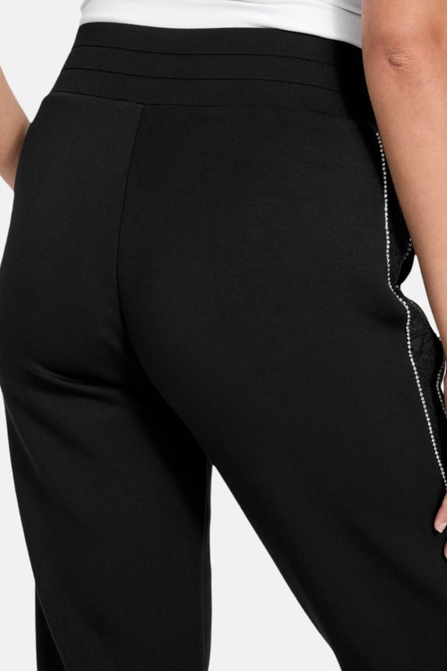 Jogging noir par Guess® avec détails de dentelle et strass sur le côté.