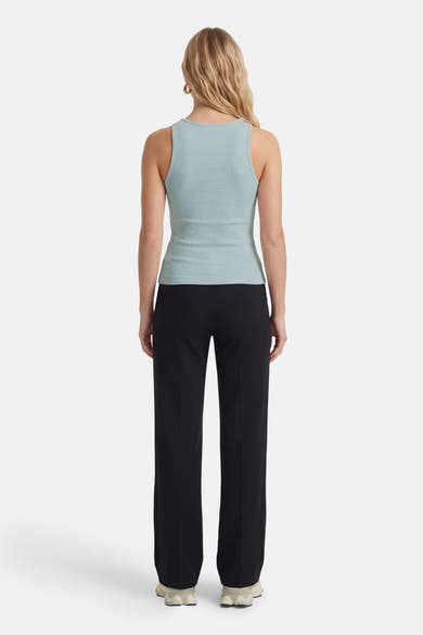 Groen mouwloos topje van Guess®, gedragen met een zwarte broek, achterzicht.