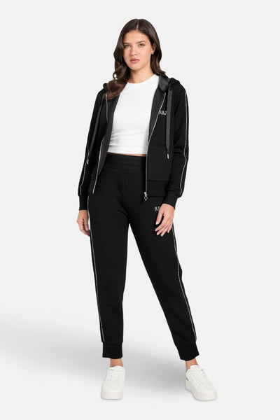 Zwarte Guess bodywarmer met ritssluiting gedragen over een wit T-shirt en een bijpassende joggingbroek.