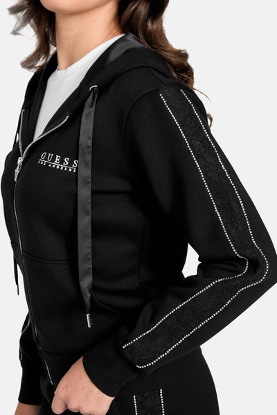 Gilet noir de Guess avec fermeture éclair, capuche à cordon, et rayures décoratives le long des manches.