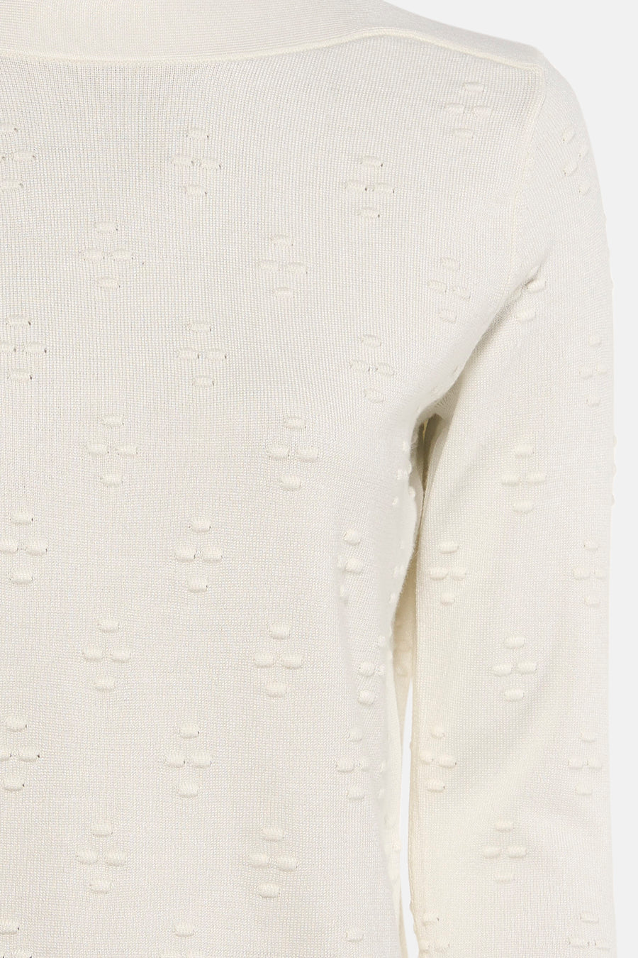 Pull à col rond écru de Zabaione, avec un motif en croix en relief et une texture tricotée.