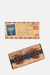 Nœud papillon en bois marron de Mr. Célestin, avec motif ajouré de feuilles et écrin assorti.