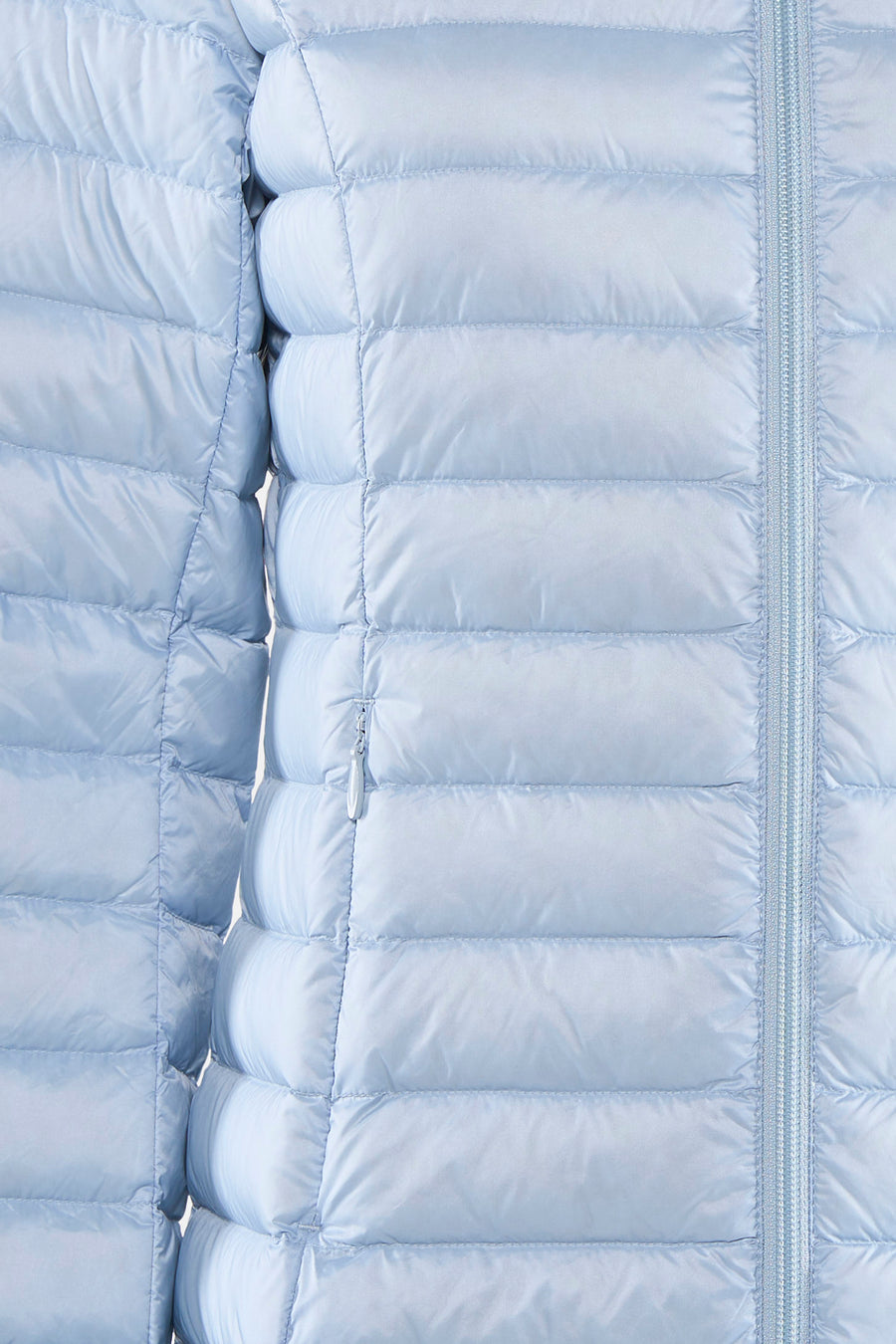 Imperméable bleu clair de JOTT, à matelassage horizontal et fermeture éclair ton sur ton.