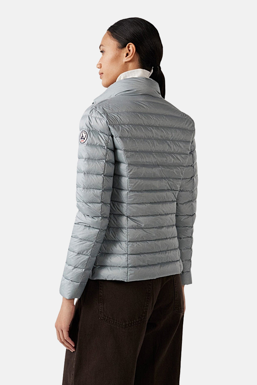 Veste de pluie grise de JOTT, avec un motif matelassé horizontal et un col montant.