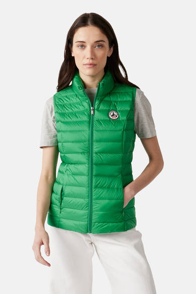 Groen mouwloos gewatteerd vest van JOTT, gedragen met een grijs T-shirt en een witte broek, van achteren gezien.