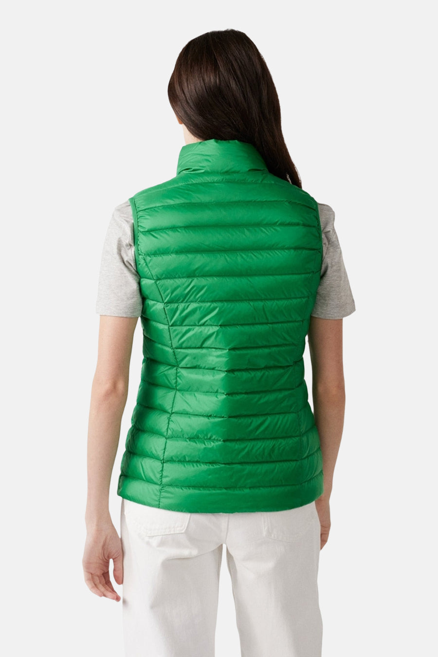 Veste sans manches verte de JOTT, matelassée, portée avec un t-shirt gris et un pantalon blanc, vue de dos.
