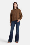 Chemise marron à manches longues par ADORE, avec coutures contrastantes et poches plaquées, portée avec un jean évasé.
