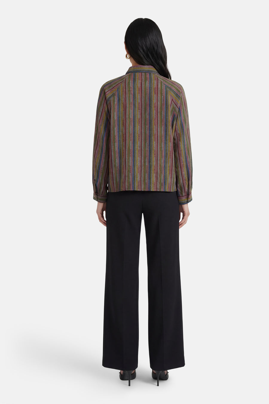 Chemise à manches longues multicolore d'ADORE, à rayures verticales, portée avec un pantalon noir ample.