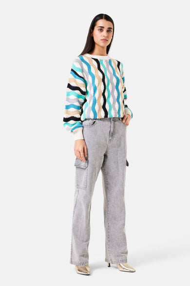 Pull à col rond multicolore de GARCIA, avec motifs graphiques ondulés et porté avec un pantalon cargo gris.
