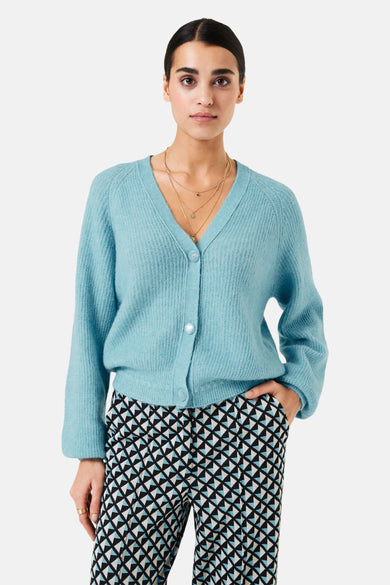 Gilet bleu GARCIA avec des boutons nacrés, porté sur un pantalon à motif géométrique noir, blanc et bleu.