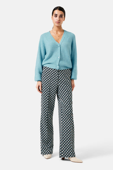 Gilet bleu de GARCIA avec des boutons et porté avec un pantalon à motif géométrique.