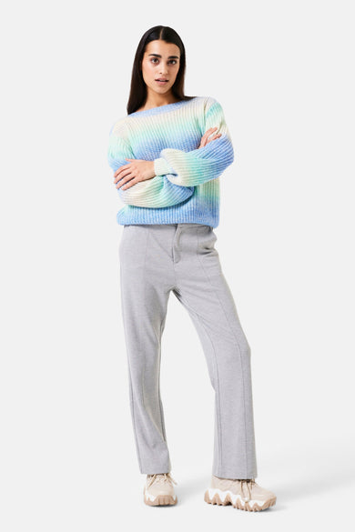 Pantalon gris de GARCIA, avec coutures verticales sur le devant et porté avec un pull multicolore.
